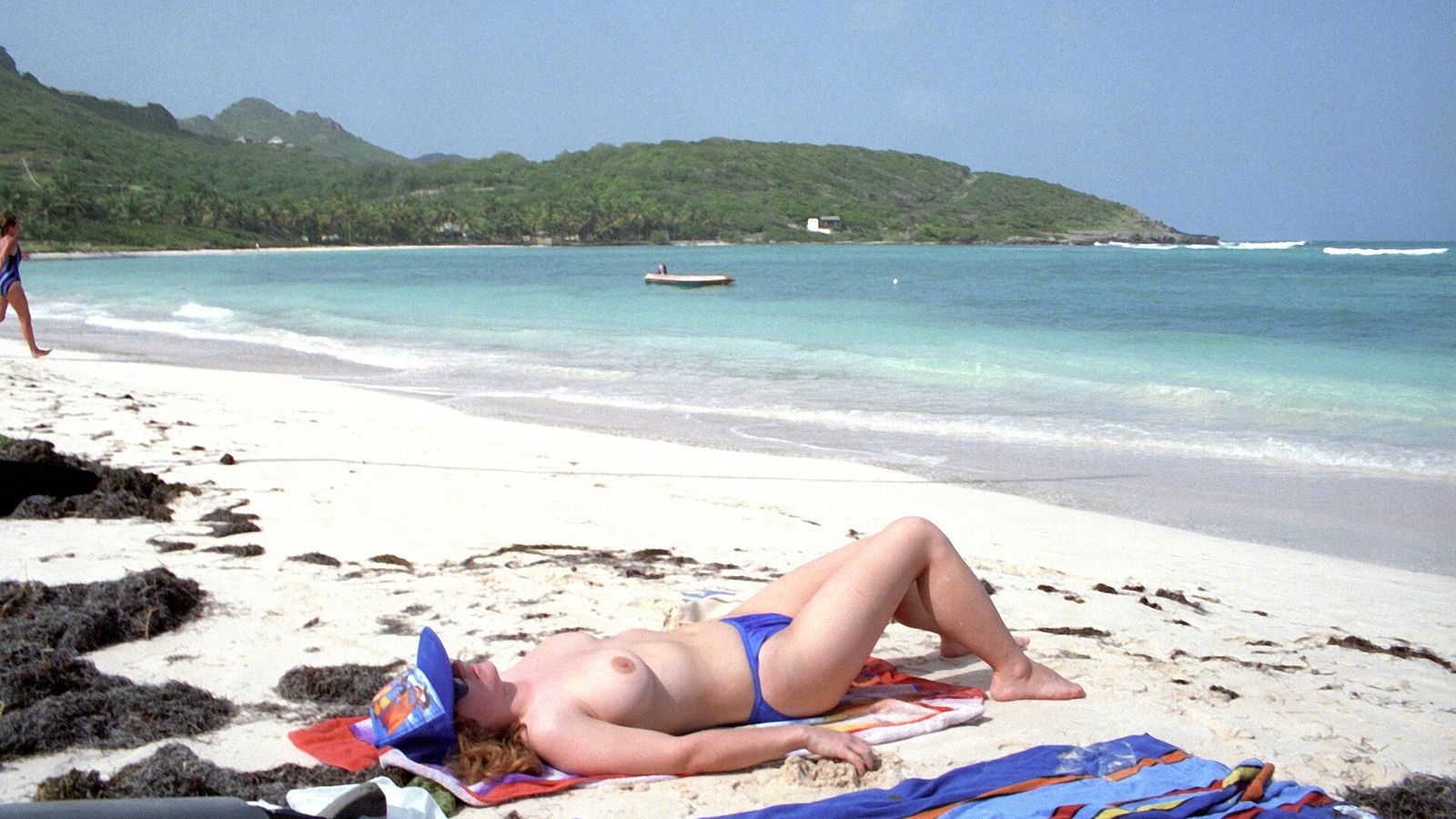 Handdoek op een wit zandstrand aan turquoise zee