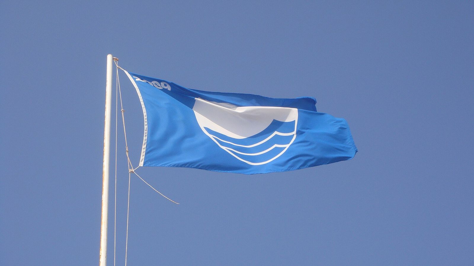 De Blauwe Vlag wappert boven een strand